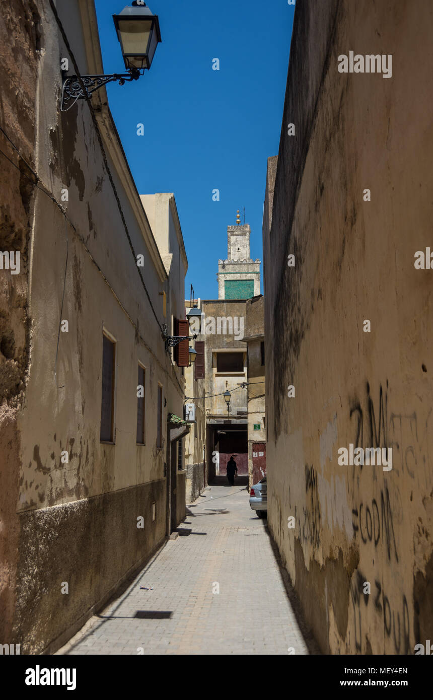 Meknes, Marokko - 8. Mai 2017: typische Straße Schmal von Meknes mit Minarett der Madrasa Bou Inania im Hintergrund, Marokko. Meknes ist eine der vier Im Stockfoto