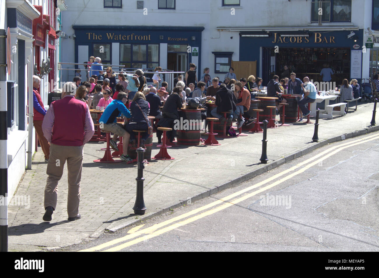 Die Menschen Essen und Trinken außerhalb der Kneipen und Restaurants von Baltimore Meer. Baltimore ist ein beliebtes Urlaubsziel in Irland. Stockfoto