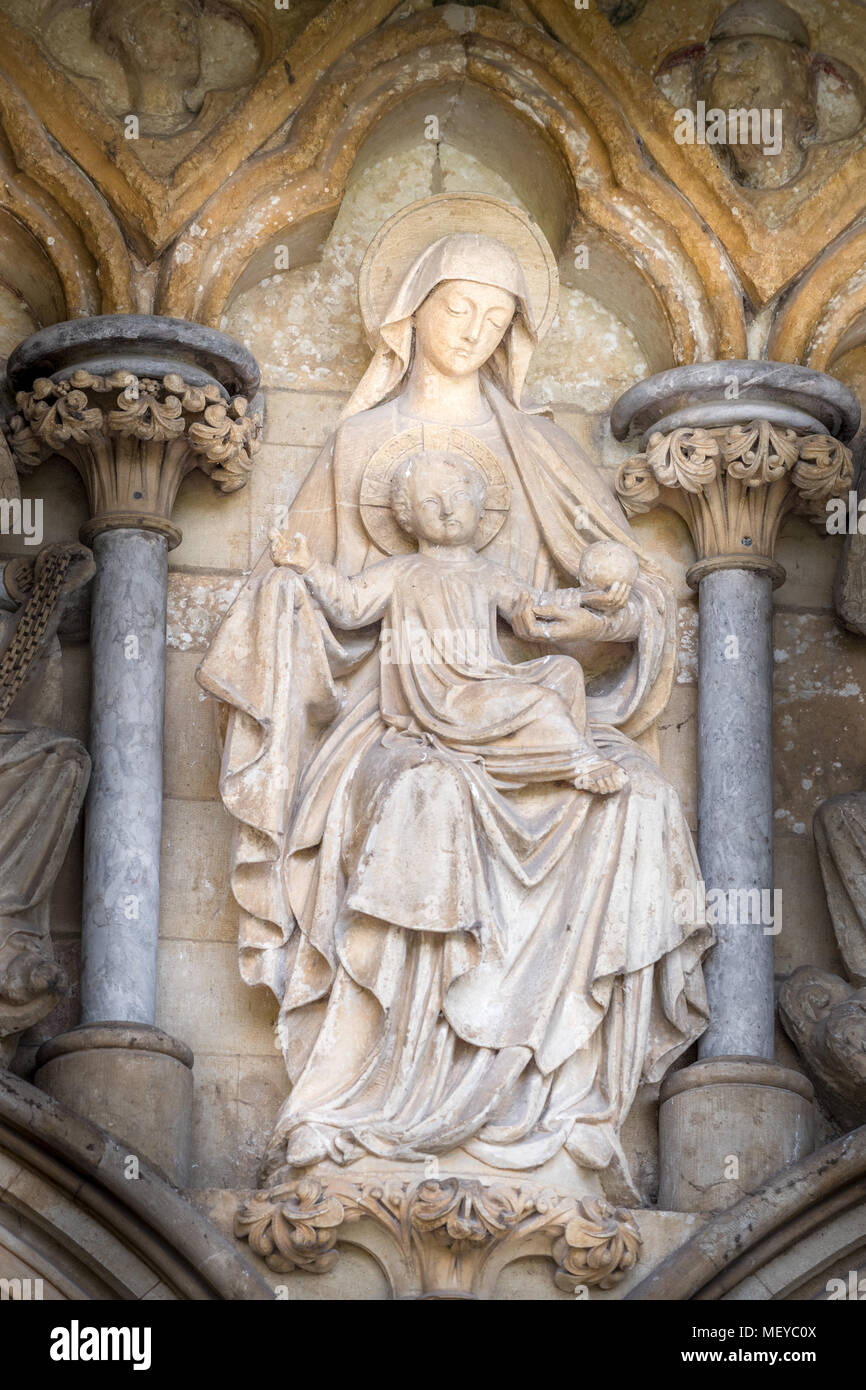 Sculpted Stein Statue der Maria und Jesus auf der Wand über dem Westportal Eingang an der mittelalterlichen Kathedrale der Hl. Jungfrau Maria in Salisbury, England Stockfoto