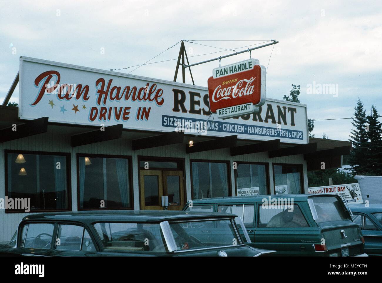 Fassade eines klassischen amerikanischen Drive in Restaurant, die Pan Handle Drive In, mit parkenden Autos außerhalb und ein Zeichen für Coca Cola sichtbar, United States, 1965. () Stockfoto