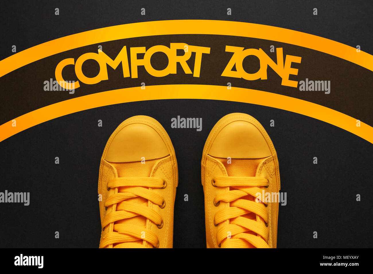 Comfort Zone Konzept, junge erwachsene Person in Gelb sneakers innerhalb des Kreises stehend, Ansicht von oben Stockfoto