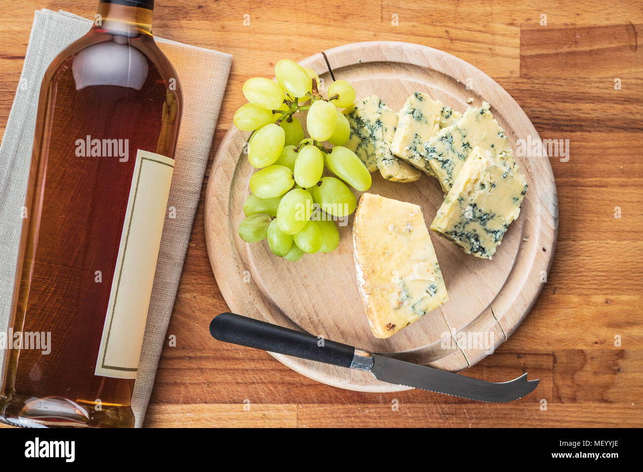 Leckere blaue Käse mit Trauben auf Schneidebrett. Stockfoto