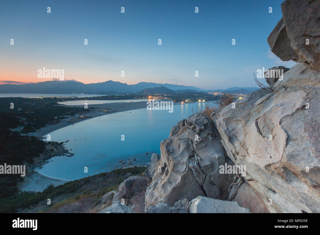 Top Aussicht auf die Bucht mit sandigen Stränden und Lichter eines Dorfes in der Abenddämmerung Porto Giunco Villasimius Cagliari Sardinien Italien Europa Stockfoto