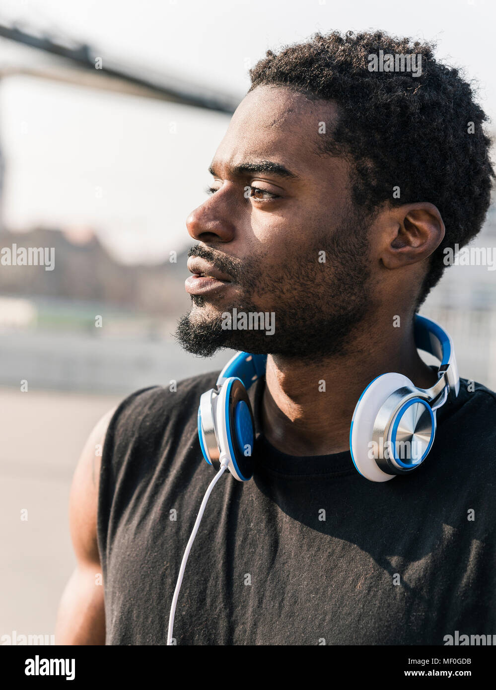 Porträt eines jungen Mannes mit Kopfhörern im Freien Stockfoto