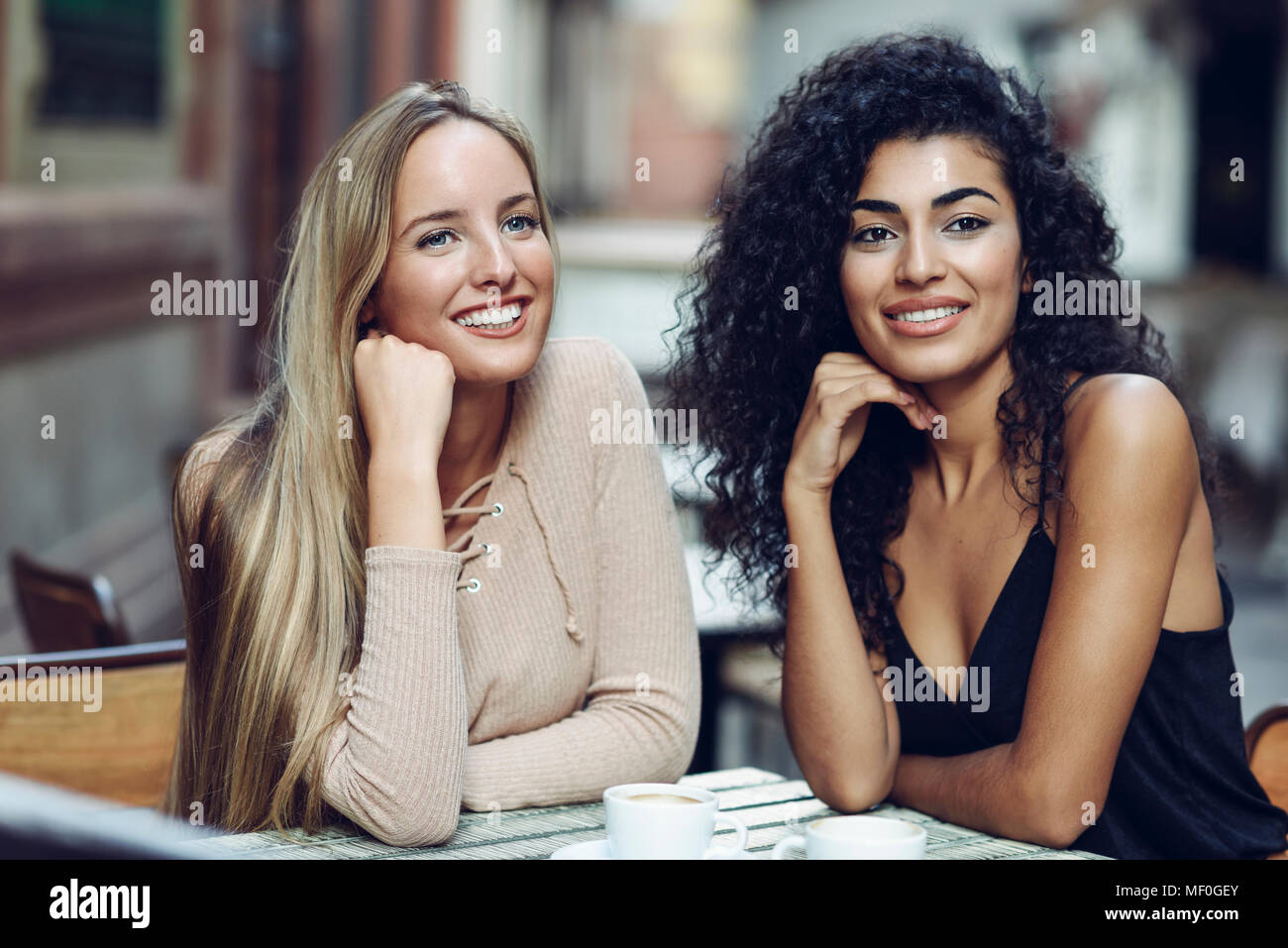 Portrait von zwei Freunden im Straßencafe sitzen etwas beobachten Stockfoto