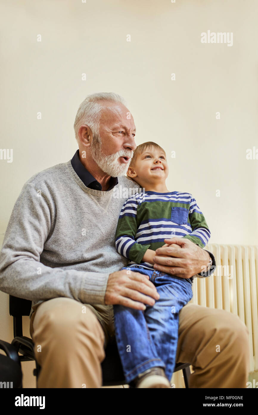 Junge sitzt auf dem Schoß der Großvater im Wartezimmer Stockfoto