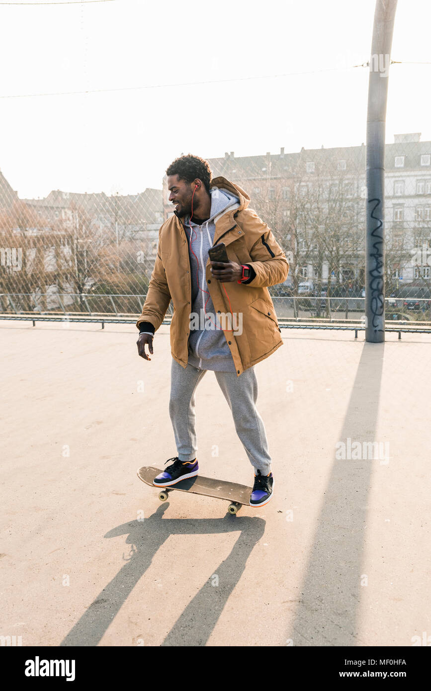 Junger Mann auf Skateboard auf Gericht Stockfoto