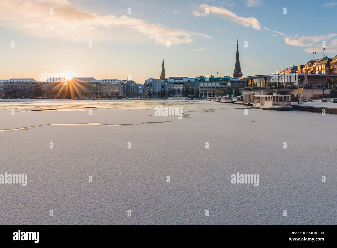 Deutschland, Hamburg, Blick auf Jungfernsteig und gefrorene Binnenalster bei Sonnenaufgang Stockfoto