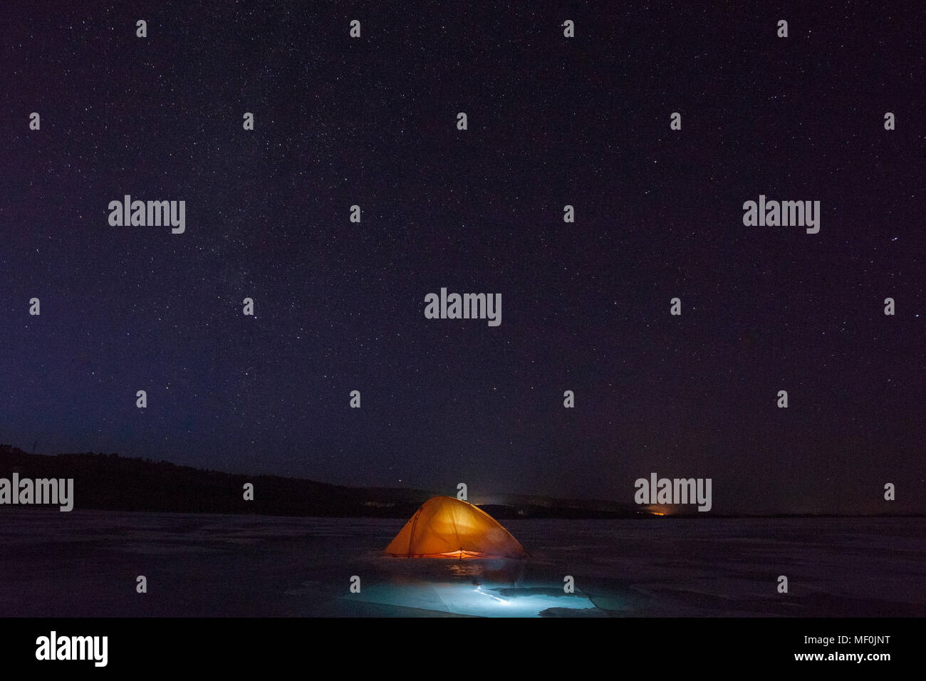 Russland, Amur Oblast, beleuchtetes Zelt auf gefrorenen Zeya Fluss in der Nacht unter Sternenhimmel Stockfoto