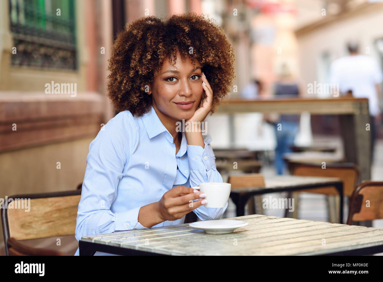 Spanien, Andalusien, Malaga. Schwarze Frau, afro Frisur, in einem Café sitzen. Mädchen mit formalwear eine Pause. Lifestyle Konzept. Stockfoto
