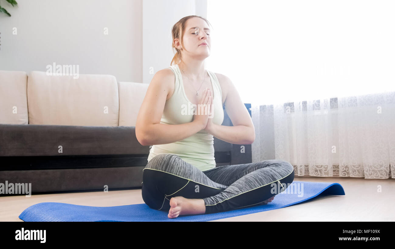 Schöne junge Frau Yoga auf dem Boden am grossen Fenster Stockfoto