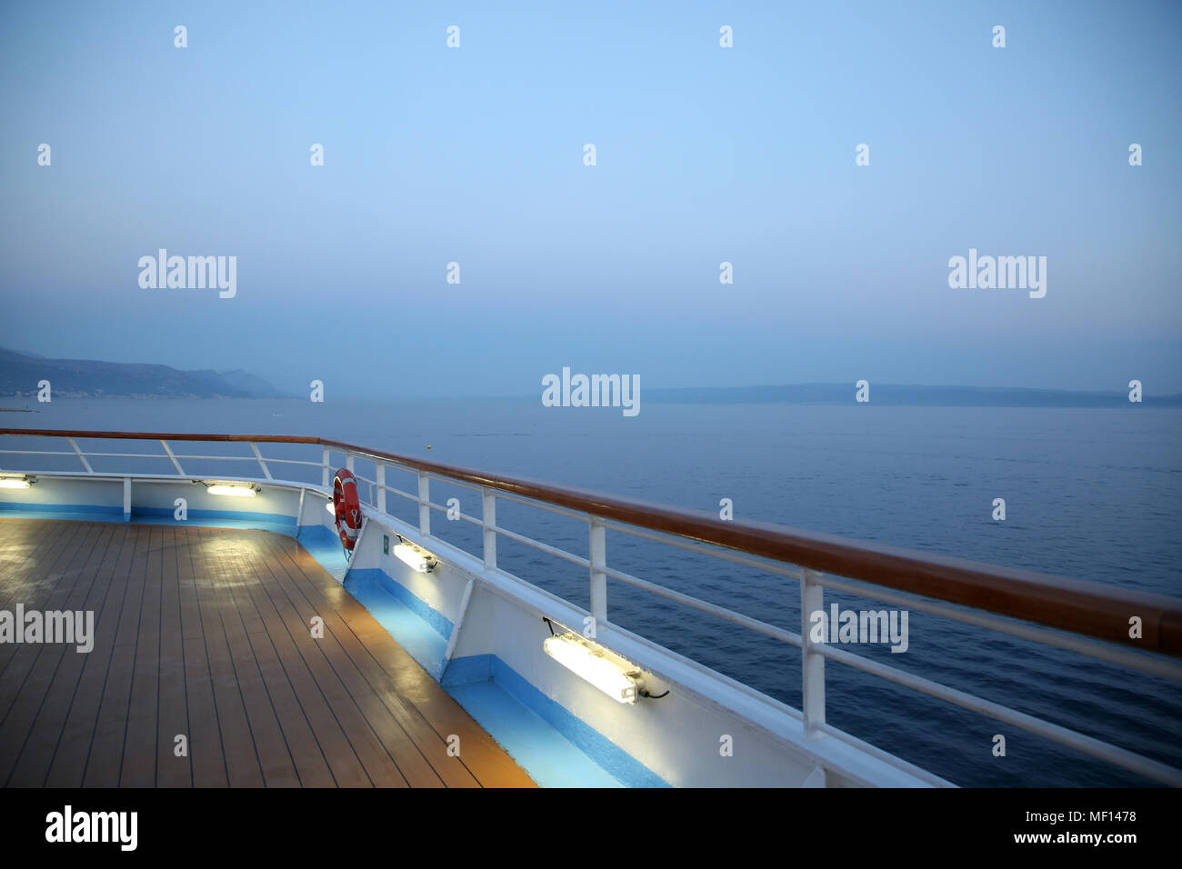 Deck eines Kreuzfahrtschiffes mit Blick auf das Meer in der Dämmerung. Das Meer ist sehr ruhig und friedlich. Stockfoto