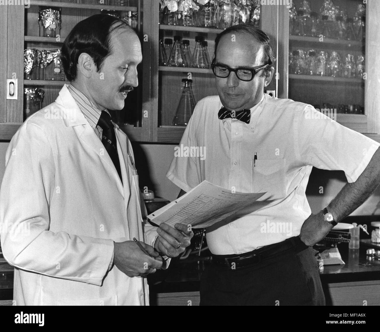 Zwei Zentren für Krankheitskontrolle (CDC) Mitarbeiter diskutieren Testergebnisse in einem Labor, 1976. Mit freundlicher Mitten zur Krankheit-Steuerung. () Stockfoto