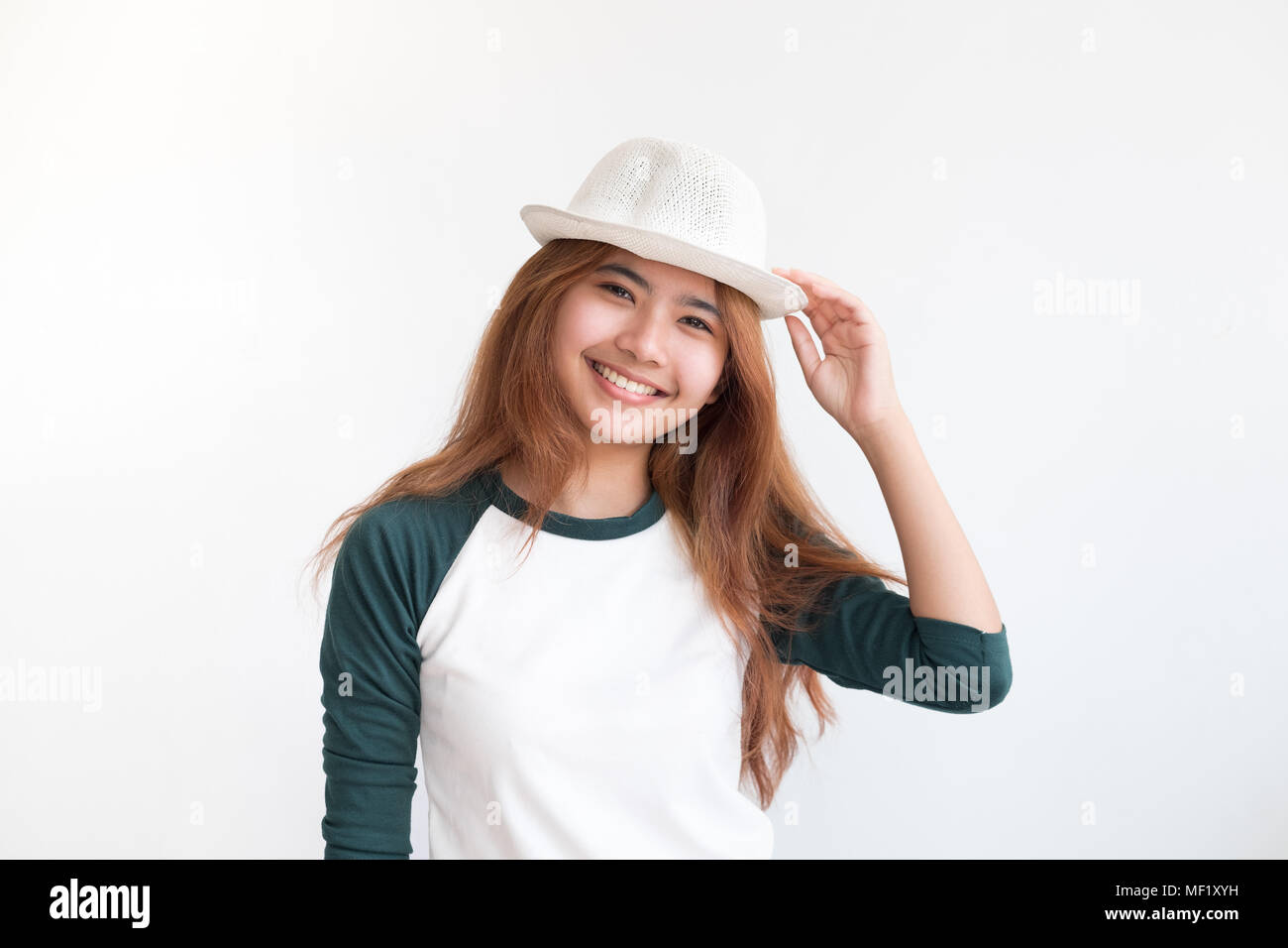 Portrait von asiatischen Teenager Frau tragen Hut mit Lächeln an der weißen Wand, Thai ethnische Stockfoto