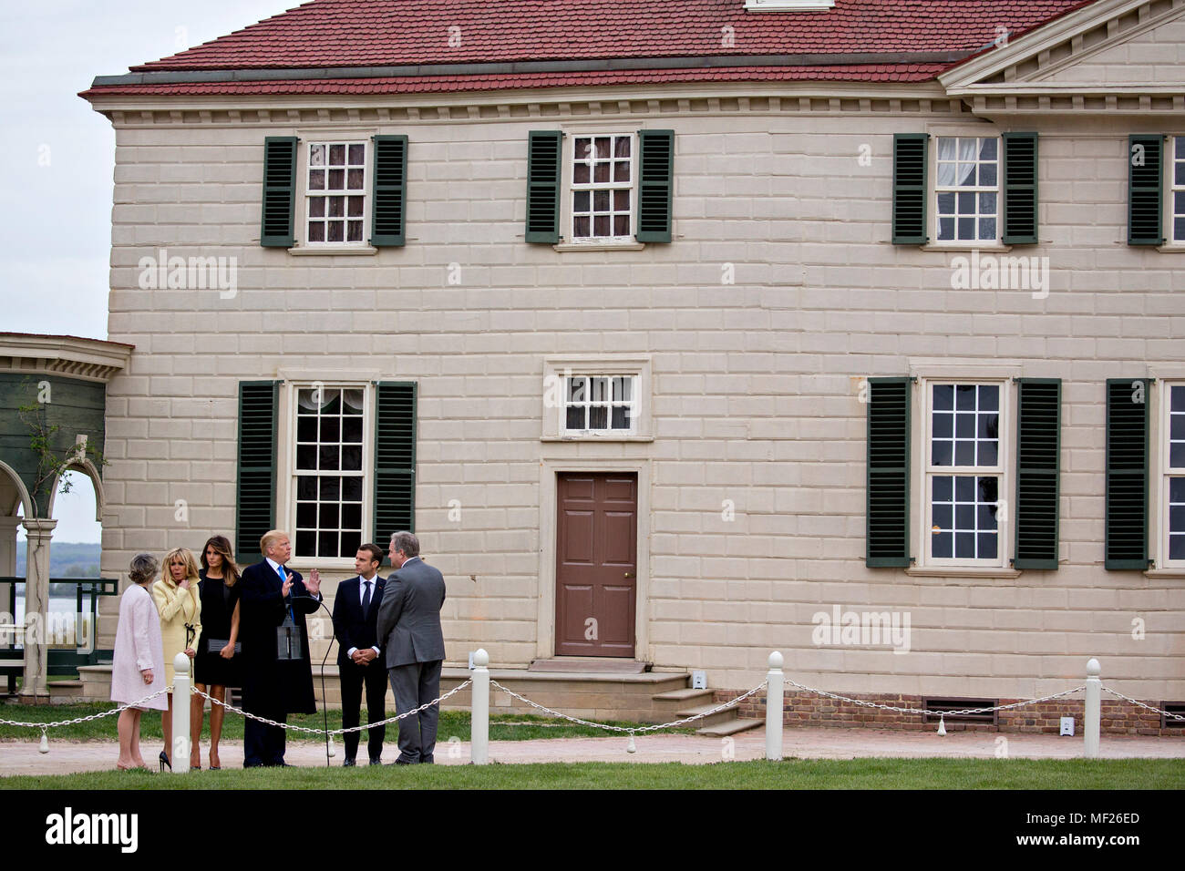 Doug Bradburn, Präsident und Chief Executive Officer von George Washington's Mount Vernon, von rechts, Emmanuel Längestrich, Frankreichs Präsident, US-Präsident Donald Trump, First Lady der USA Melania Trump, Brigitte Längestrich, ersten französischen Dame, und Sarah Miller Coulson, mit dem Mount Vernon Damen Association, Tour außerhalb der Villa am Mount Vernon Estate des ersten US-Präsidenten George Washington in Mount Vernon, Virginia, USA, am Montag, 23. April 2018 Regent. Wie Längestrich für den ersten Staatsbesuch des Präsidenten, des Trump ankommt, die US-Führer bedroht die Global Trading System w Zu hochkant Stockfoto
