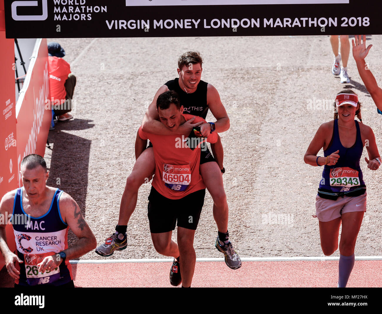 Zwei Mann Überqueren der Ziellinie in einem Pferd Stil während der Virgin Money London Marathon in London, England am 22. April 2018. Stockfoto