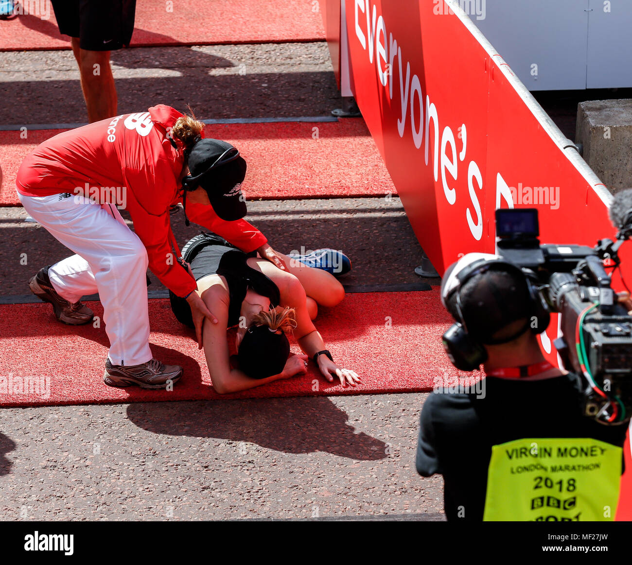 Läufer sind erschöpft, wie sie die Ziellinie in so weit die heißesten Virgin Money London Marathon in London, England am 22. April 2018. 41 tausend Menschen in der Marathon teilgenommen. Stockfoto