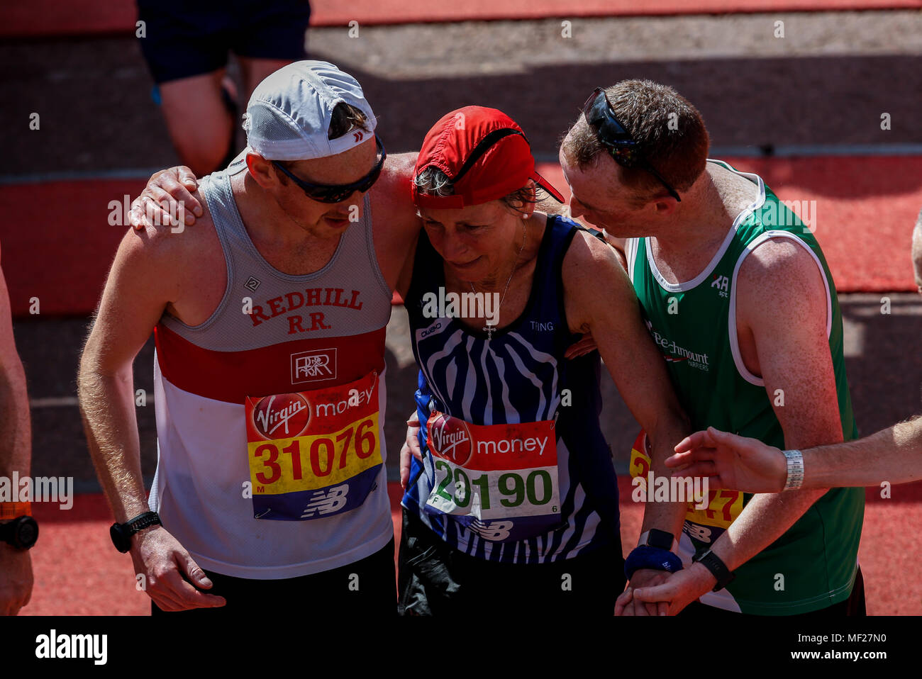 Läufer sind erschöpft, aber glücklich, als sie die Ziellinie in so weit die heißesten Virgin Money London Marathon in London, England am 22. April 2018. 41 tausend Menschen in der Marathon teilgenommen. Stockfoto