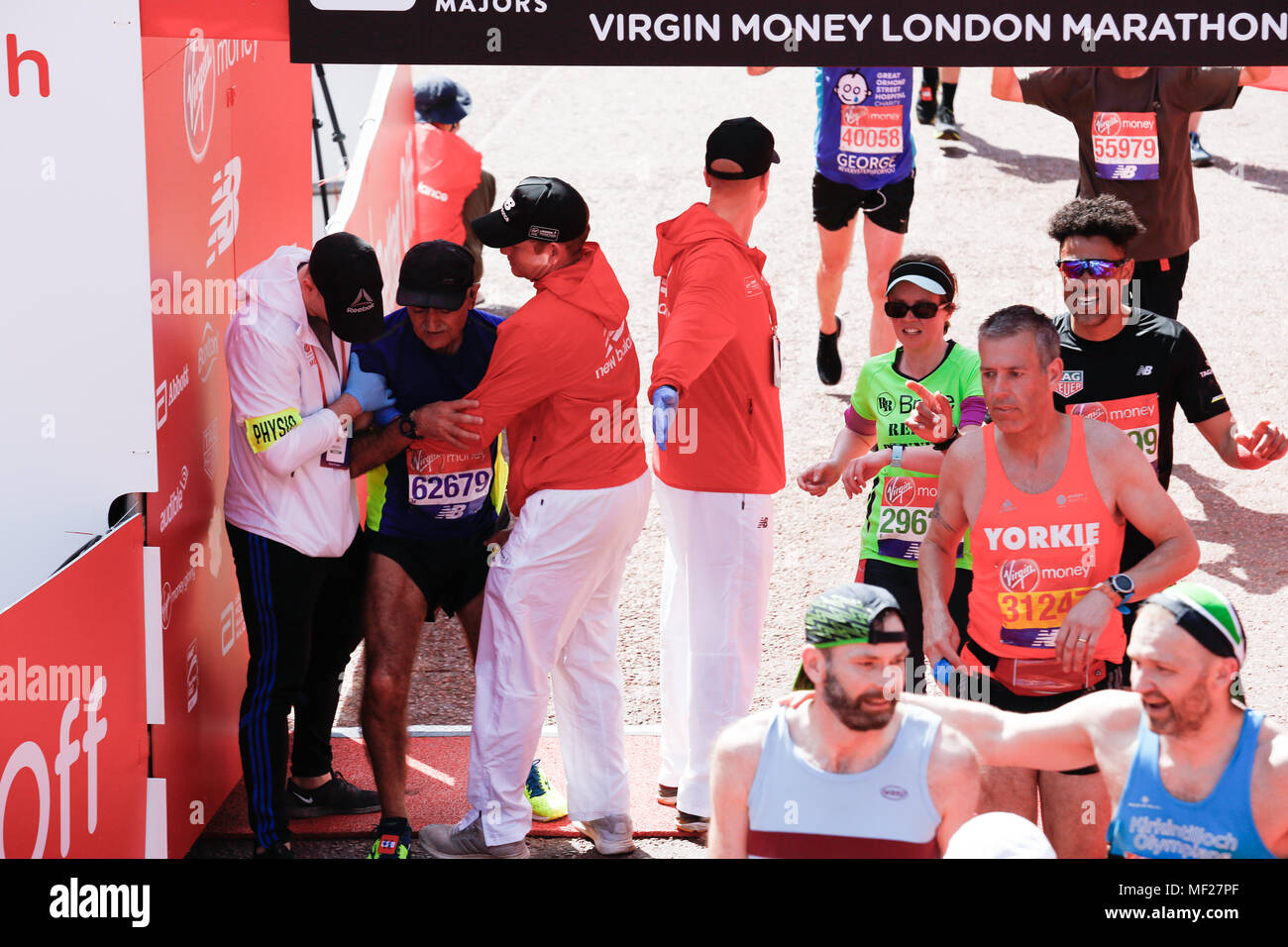 Läufer sind erschöpft, wie sie die Ziellinie in so weit die heißesten Virgin Money London Marathon in London, England am 22. April 2018. 41 tausend Menschen in der Marathon teilgenommen. Stockfoto