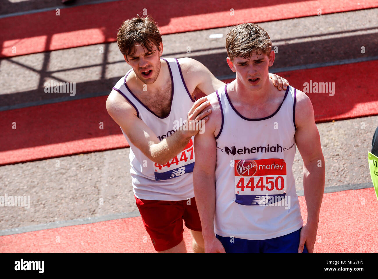 Läufer sind erschöpft, wie sie die Ziellinie in so weit die heißesten Virgin Money London Marathon in London, England am 22. April 2018. 41 tausend Menschen in der Marathon teilgenommen. Stockfoto