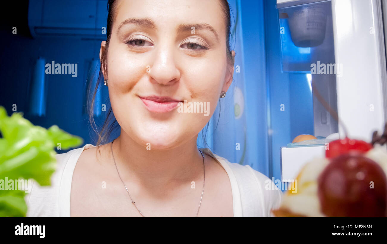 Porträt der schönen jungen Frau im Kühlschrank auf der Suche Stockfoto