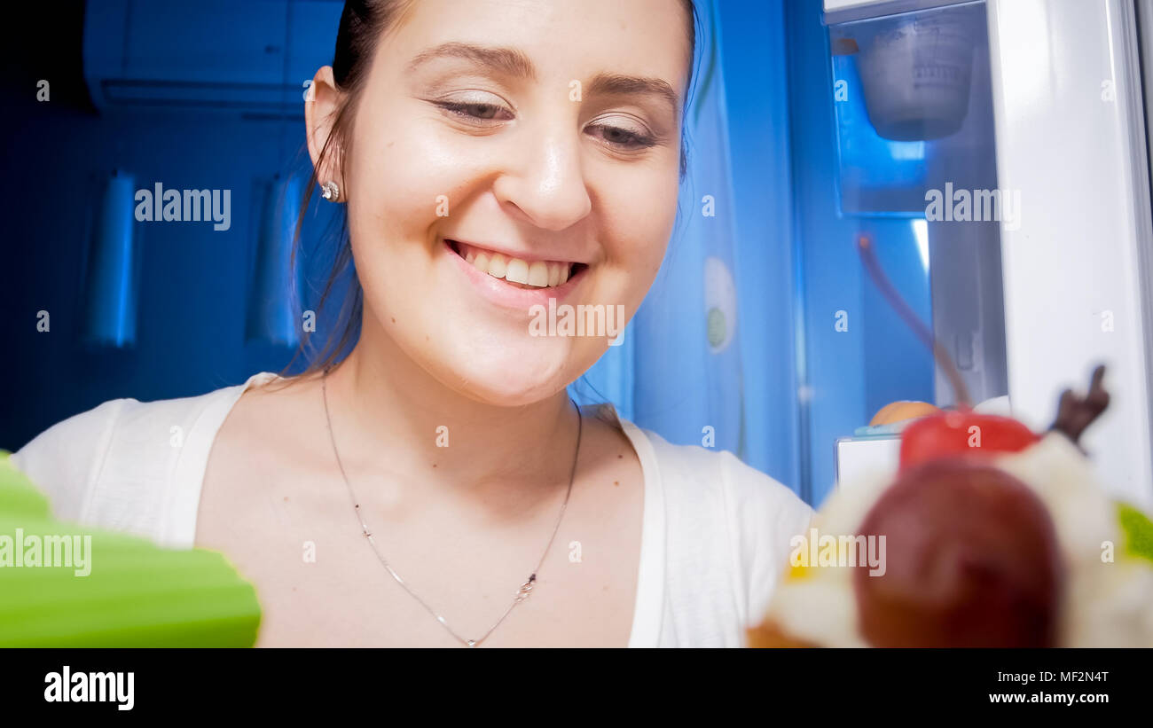 Porträt der schönen jungen Frau im Kühlschrank bei Nacht Stockfoto