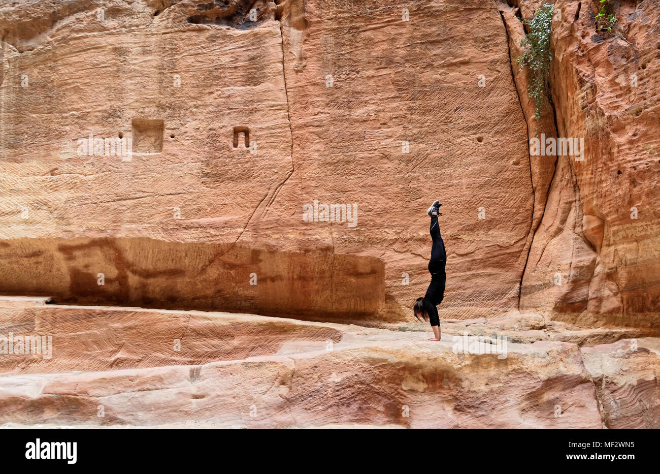 Petra, Wadi Musa, Jordanien, 9. März 2018: Junge Europäische Mädchen Training einen Handstand im siq von Petra, Naher Osten Stockfoto