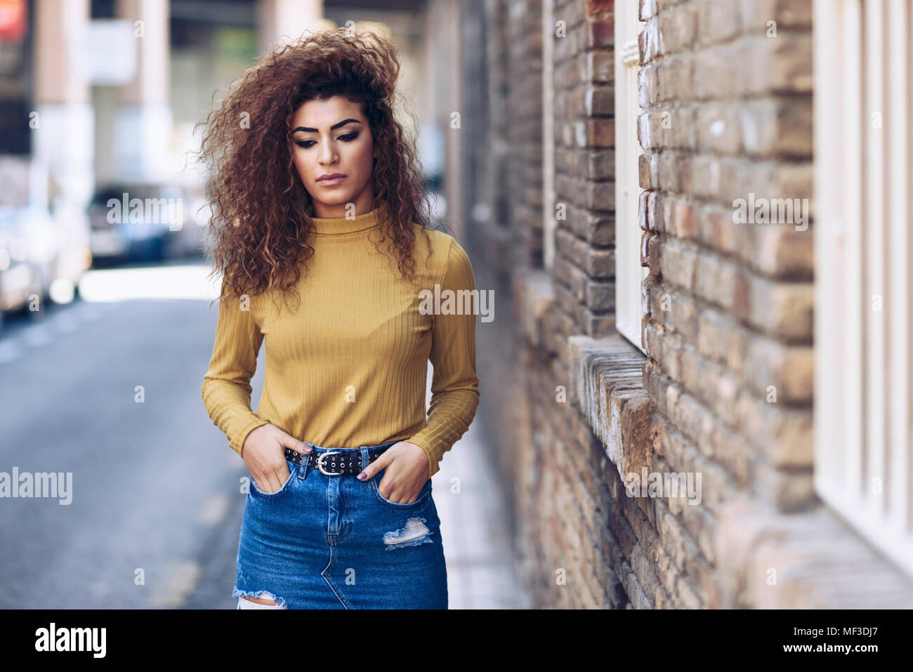 Spanien, Andalusien, Granada. Ernsthafte junge Frau mit Curly Frisur im Freien. Lifestyle Konzept Stockfoto