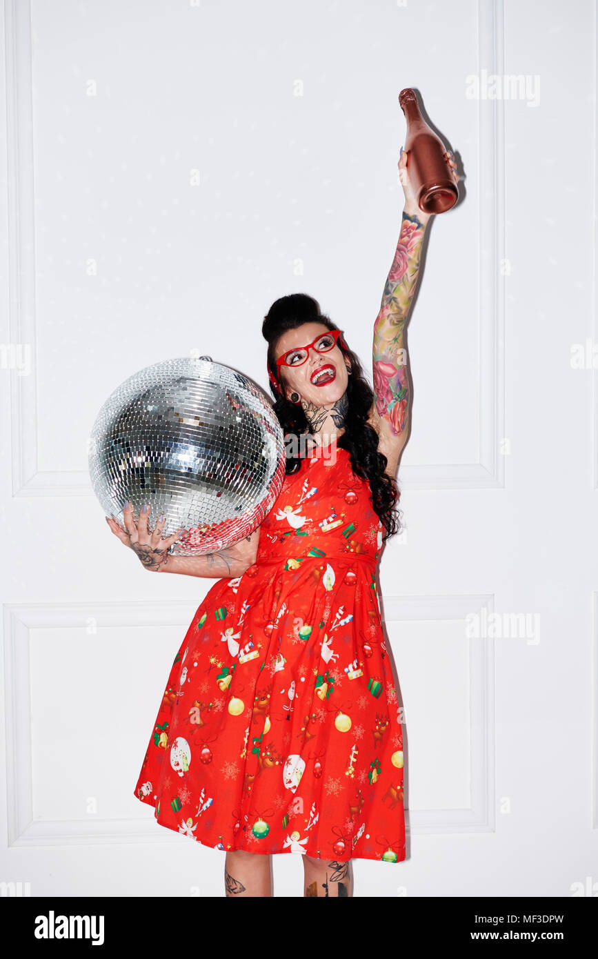 Portrait von tätowierten Frau mit Champagner Flasche und Disco ball Stockfoto