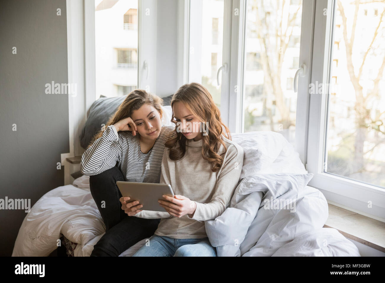 Zwei Mädchen im Teenager-Alter mit Tablette homne Stockfoto