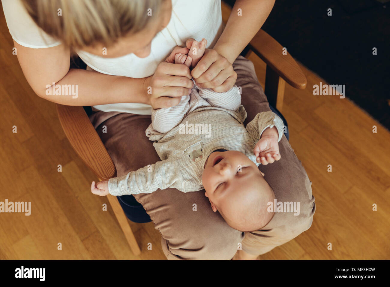 Mutter Holding up baby" Füße mit Verdauung zu helfen Stockfoto
