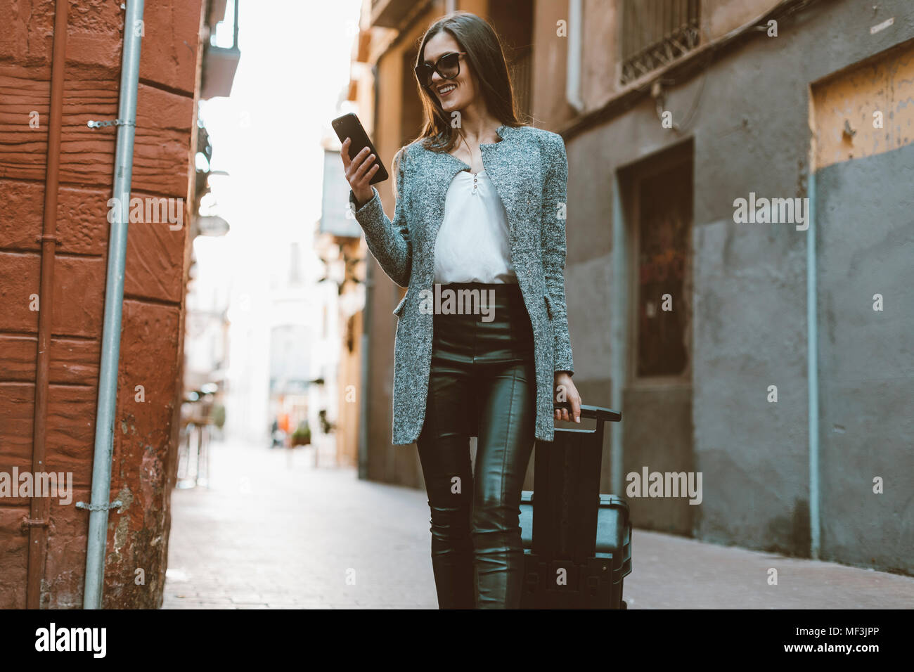 Junge Geschäftsfrau in der Stadt prüfen Handy Stockfoto