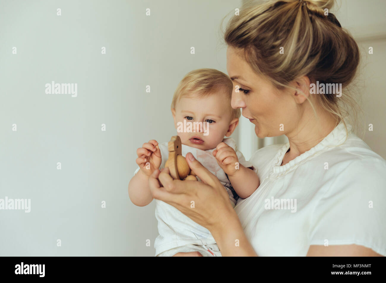 Die Mutter, die ihr Baby Holz Spielzeug Stockfoto