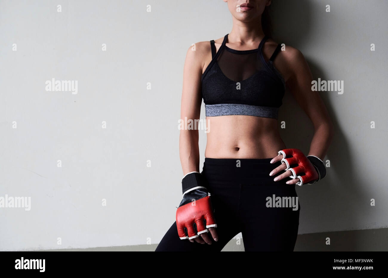 Im mittleren Abschnitt der zuversichtlich weiblichen Boxer gegen graue Wand Stockfoto