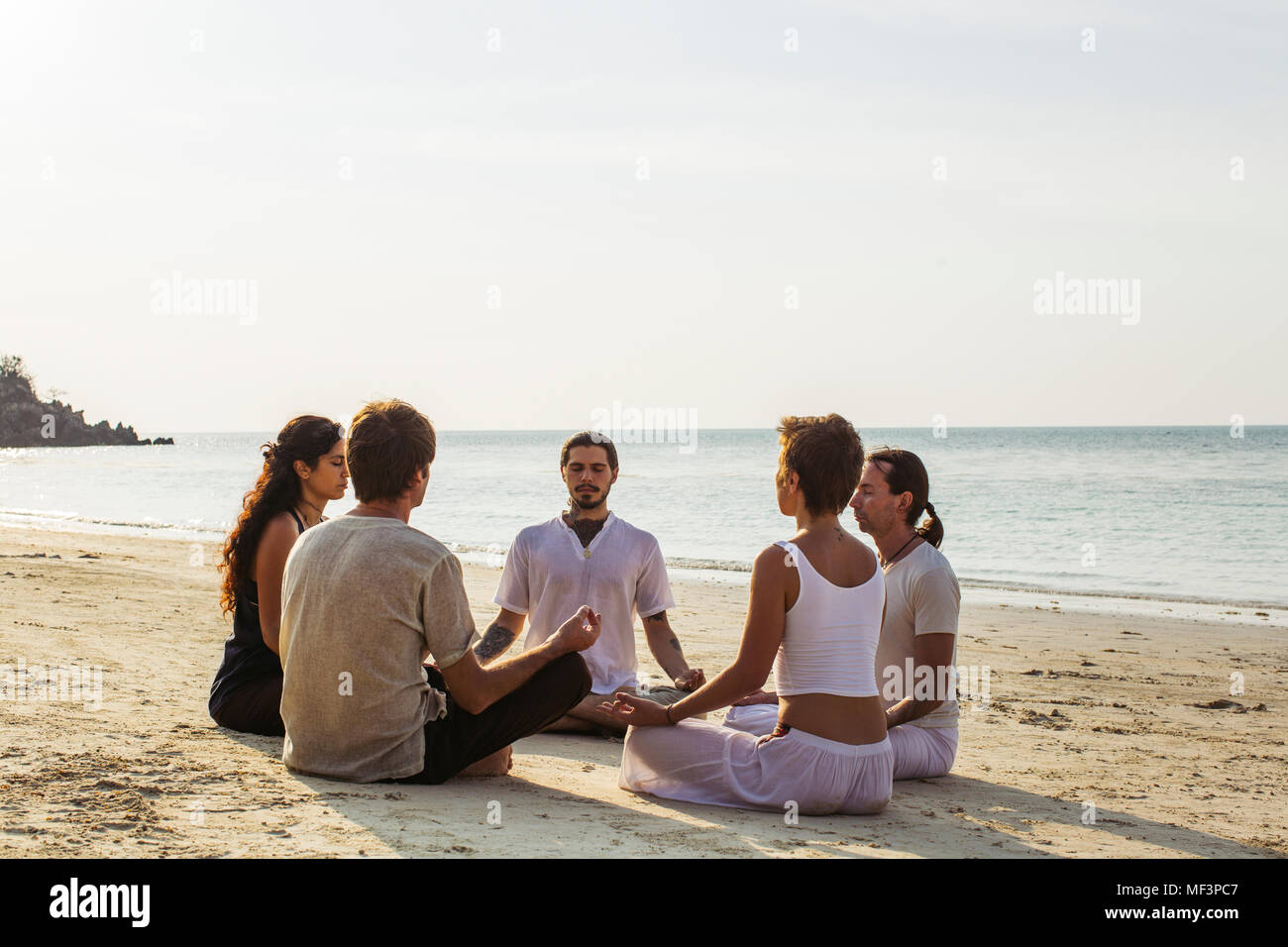 Thailand, Koh Phangan, einer Gruppe von Menschen gemeinsam meditieren am Strand Stockfoto