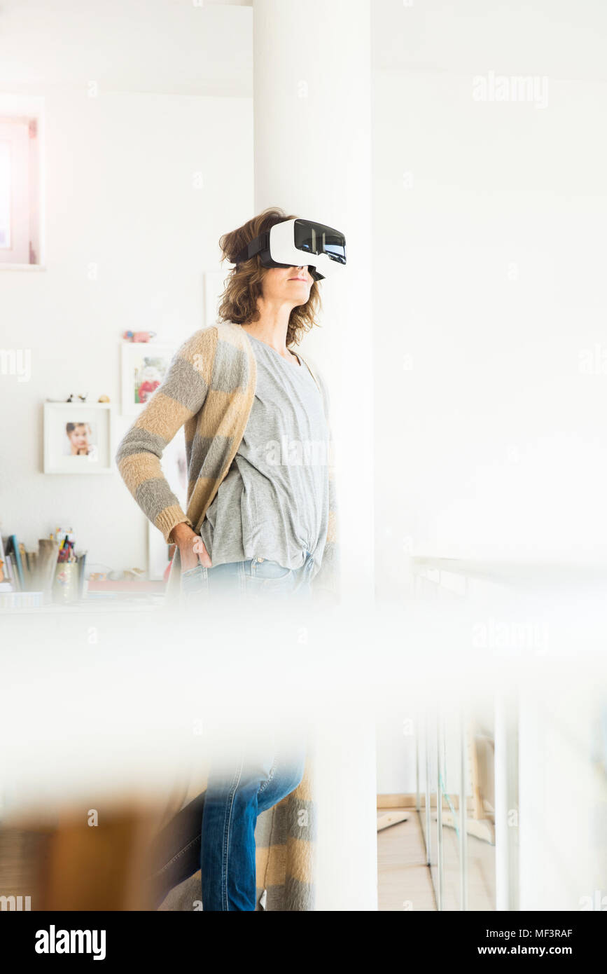 Frau mit VR-Brille zu Hause Stockfoto