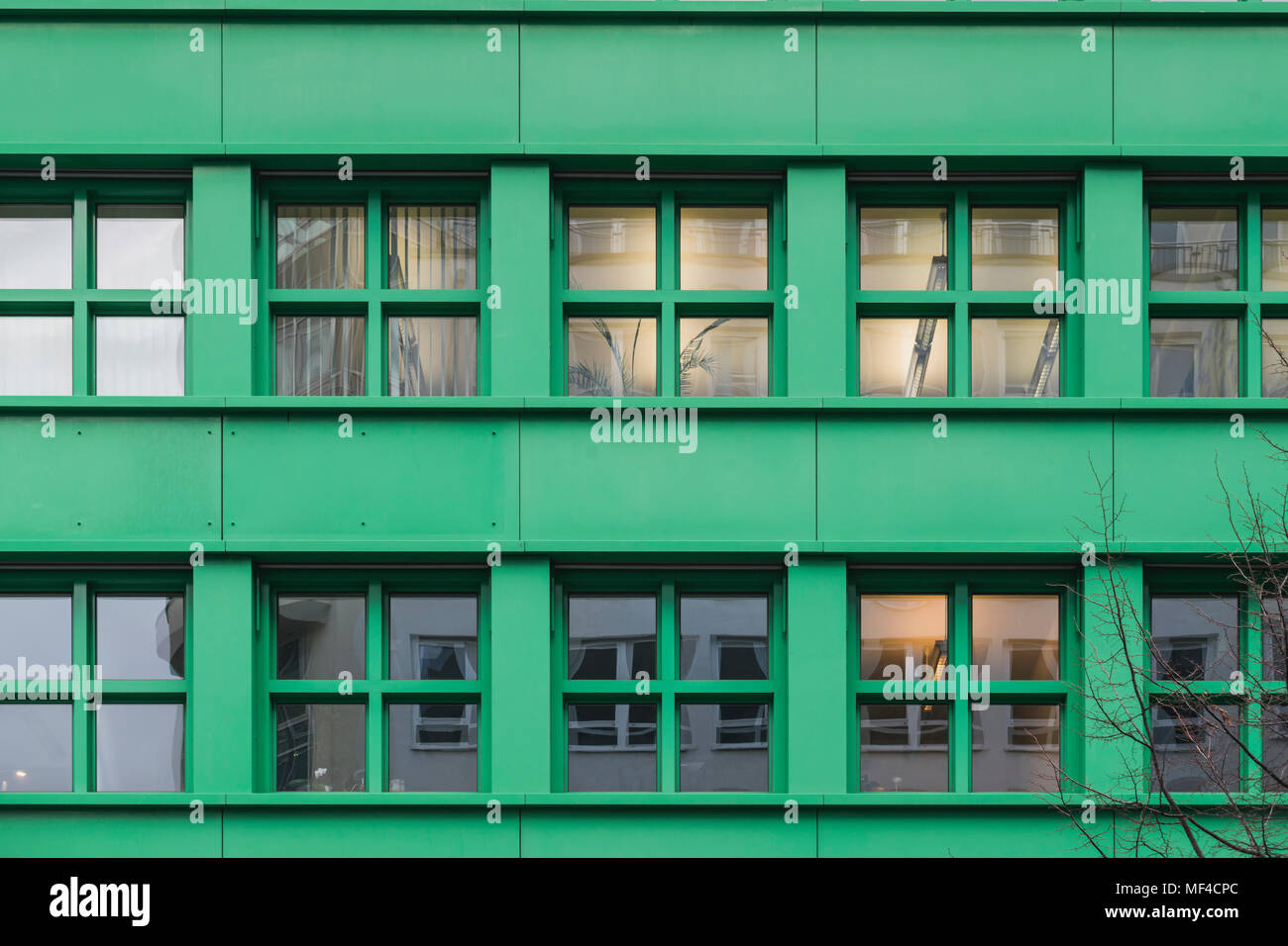 Reihe von beleuchteten Fenstern auf grüne Wand der Stadt Gebäude Stockfoto