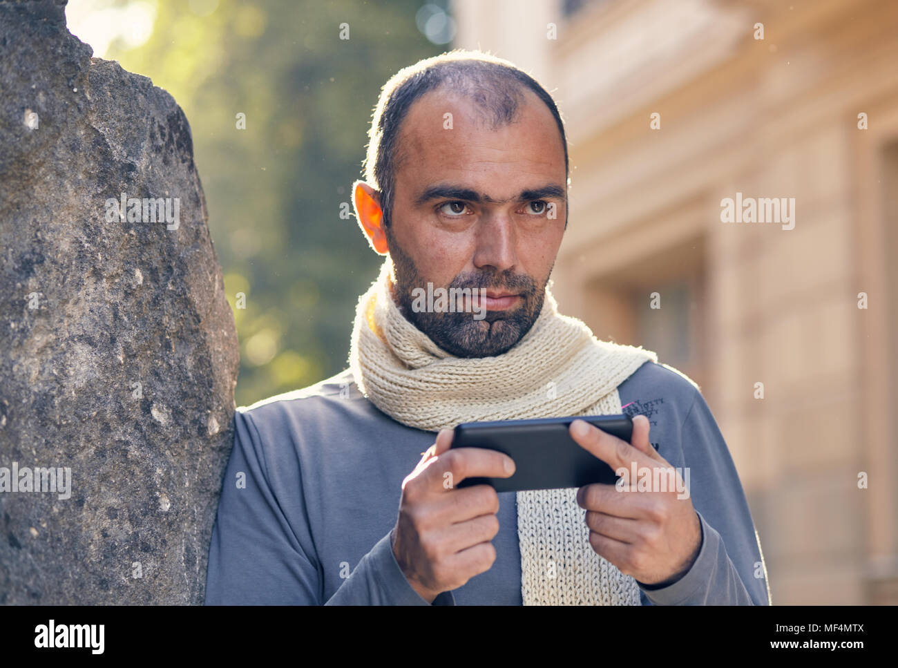 Portrait des modernen jungen Mann mit Handy auf der Straße. Stockfoto