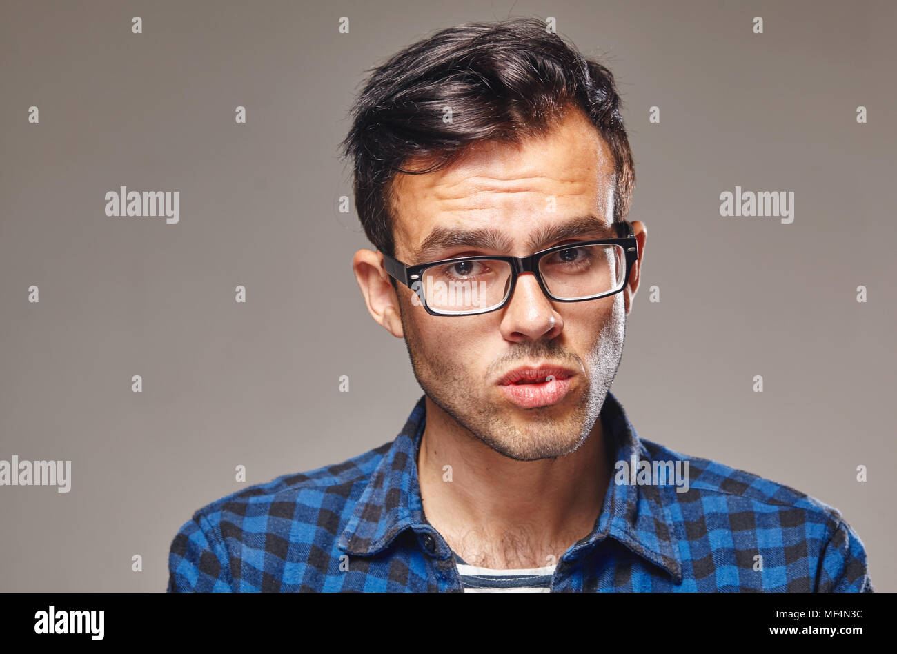 Junger Mann stehend über grauen Hintergrund. Stockfoto