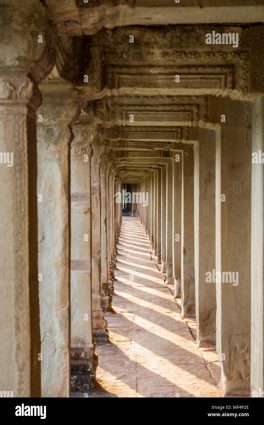 Innerhalb der äußeren Korridor von Angkor Wat, Siem Reap, Kambodscha. Die Spalten werfen ihre Schatten auf den Boden aus großen Steinplatten. Stockfoto
