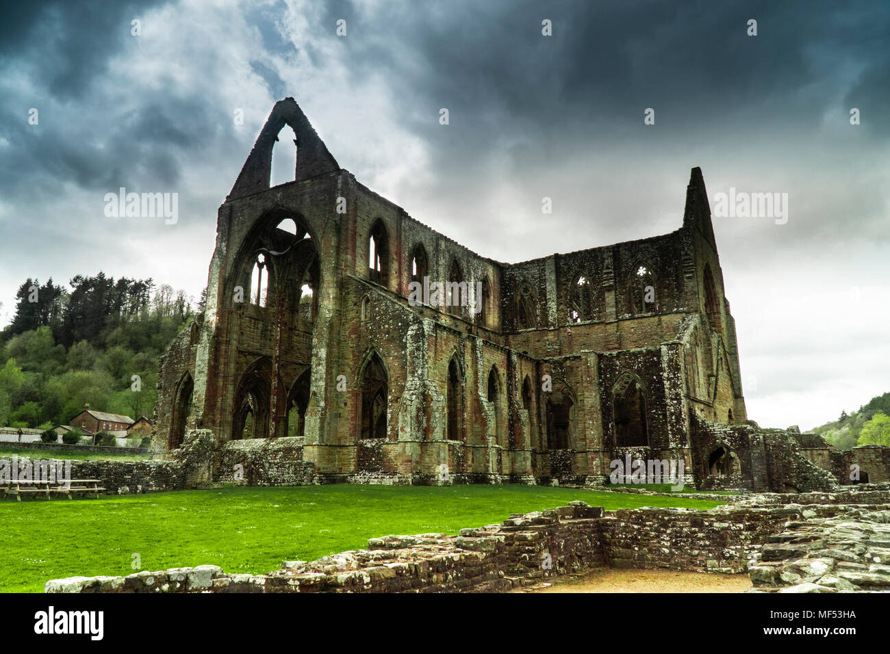 Ruinen von Tintern Abbey durch Fluss Wye in Monmouthshire, South Wales, UK. Übersicht Bögen, Schatten und Licht zeigt antike Architektur. Stockfoto