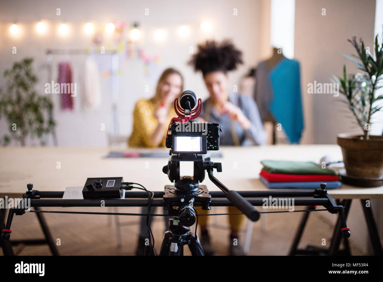 Eine Kamera und ein Schieberegler mit Frauen im Hintergrund, Startup Unternehmen. Stockfoto