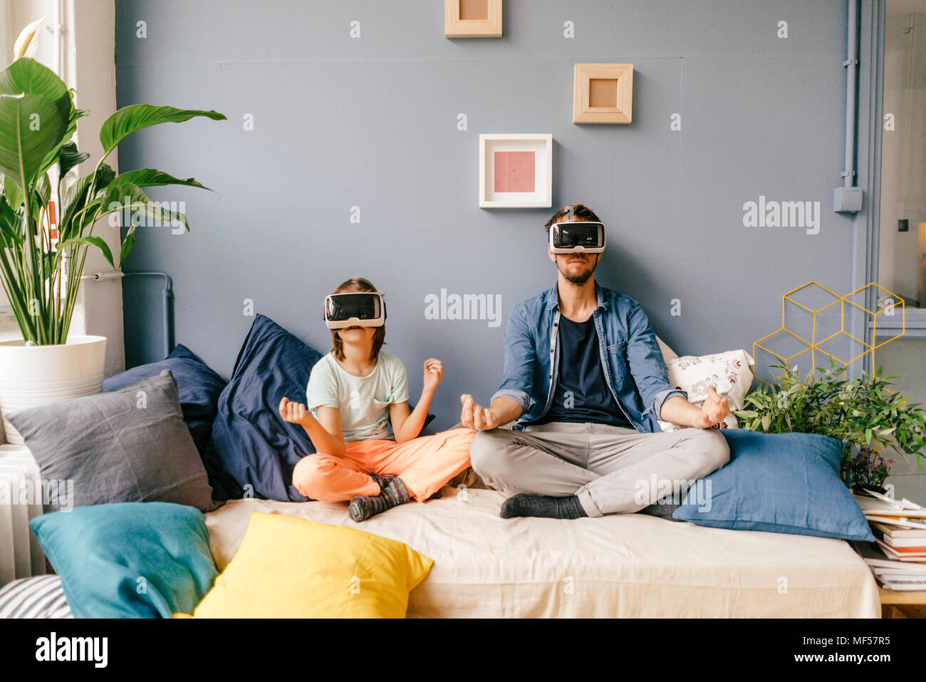 Vater und Sohn tragen VR-Brille Yoga zu Hause Stockfoto