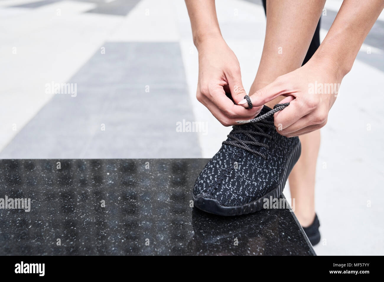 Frau binden ihr Schuh vor dem Training Stockfoto