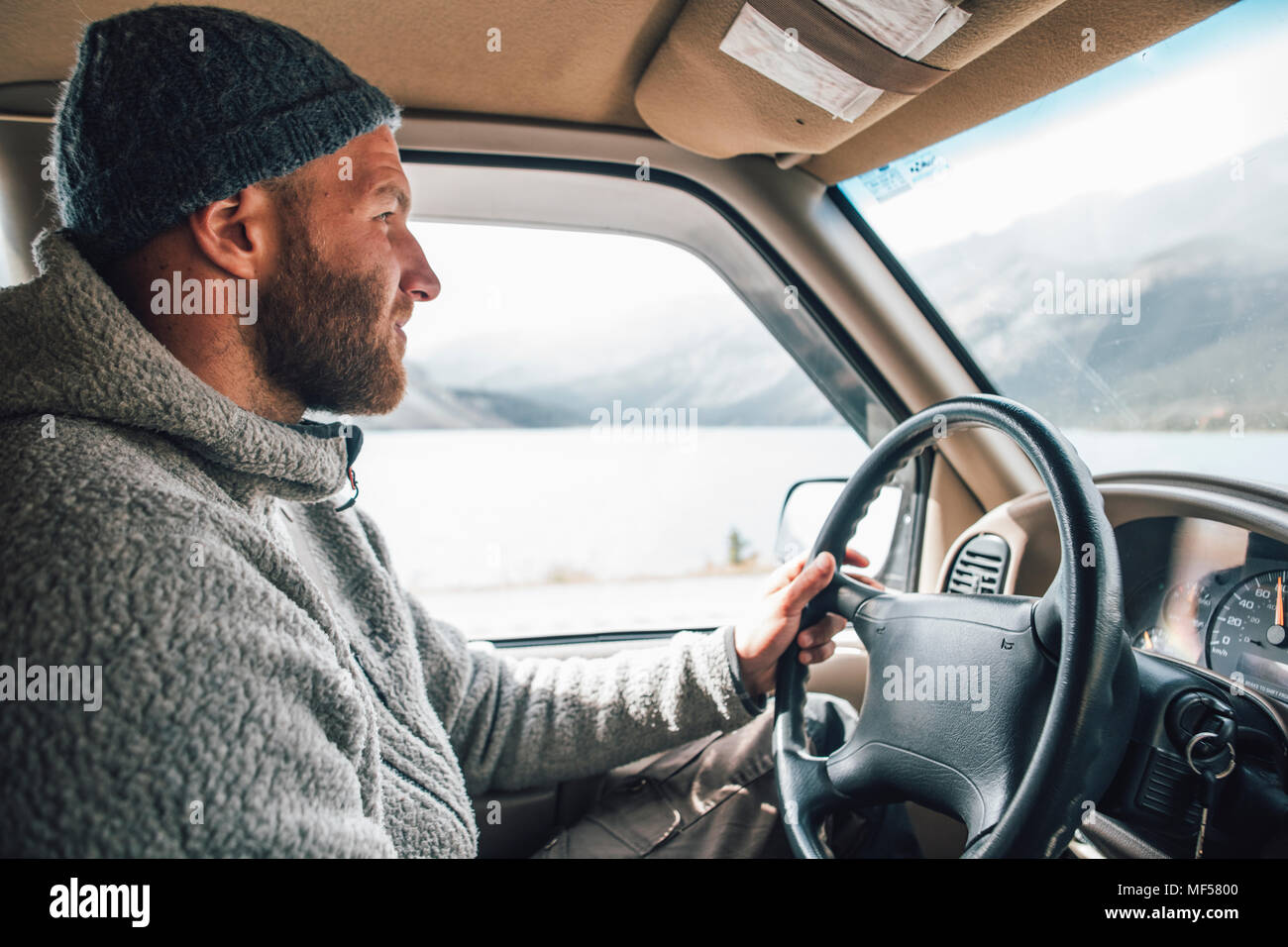 Junger Mann mit Mütze und Bart auf einen Road Trip Stockfoto