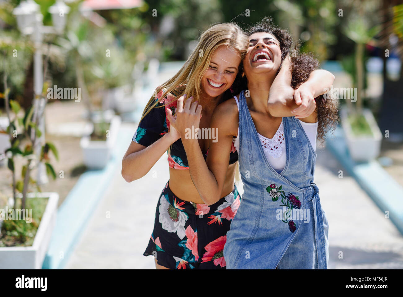 Spanien, Andalusien, Marbella. Zwei multirassischen Frauen in einer städtischen Straße. Gerne Freunde. Lifestyle Konzept. Stockfoto