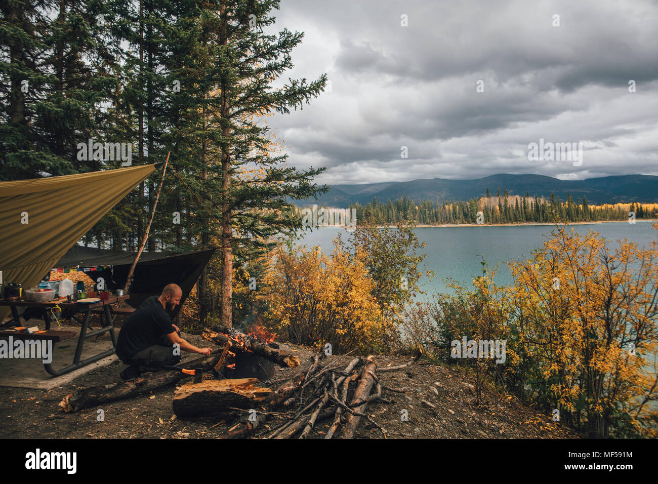 Kanada, British Columbia, Mann, Lagerfeuer bei Boya Lake Stockfoto