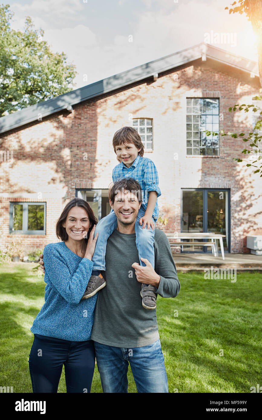 Portrait der glücklichen Familie mit Sohn im Garten ihres Hauses Stockfoto