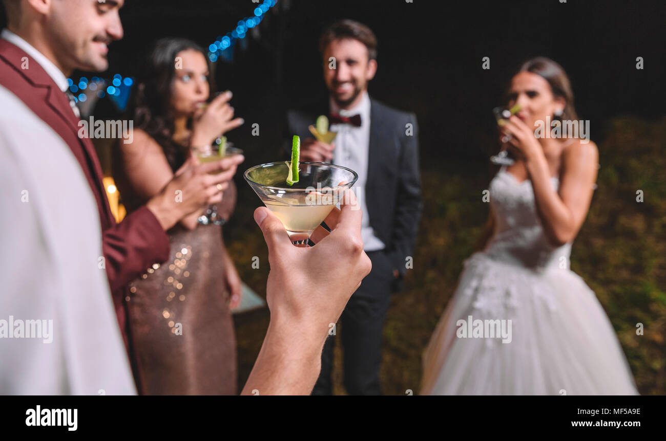 Gerne Freunde trinken Cocktails in einer Nacht Feld Hochzeitsfeier Stockfoto