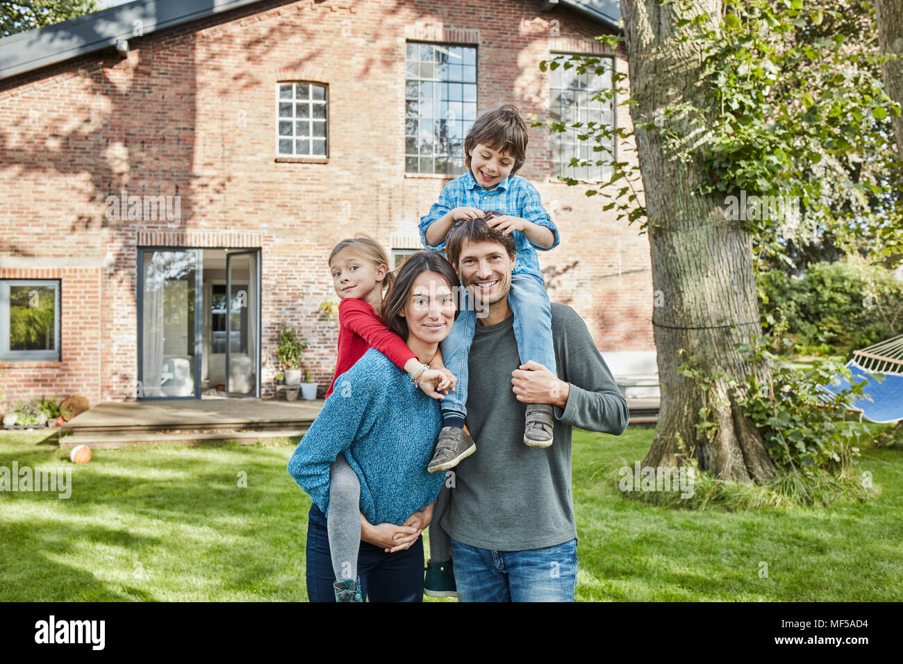 Portrait von Happy Family im Garten ihres Hauses Stockfoto